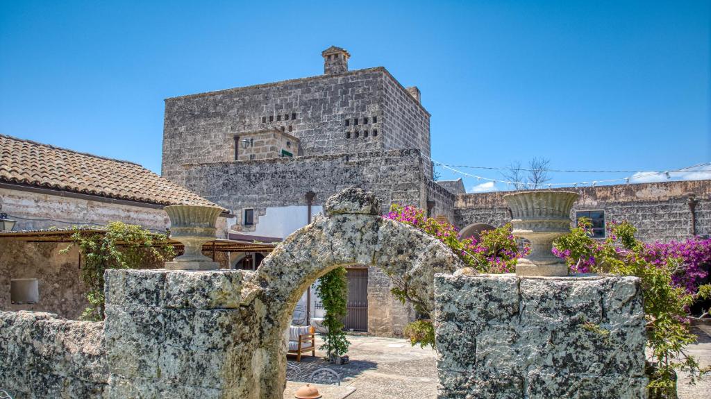 un arco de piedra frente a un edificio en BioMasseria Santa Lucia en Alessano