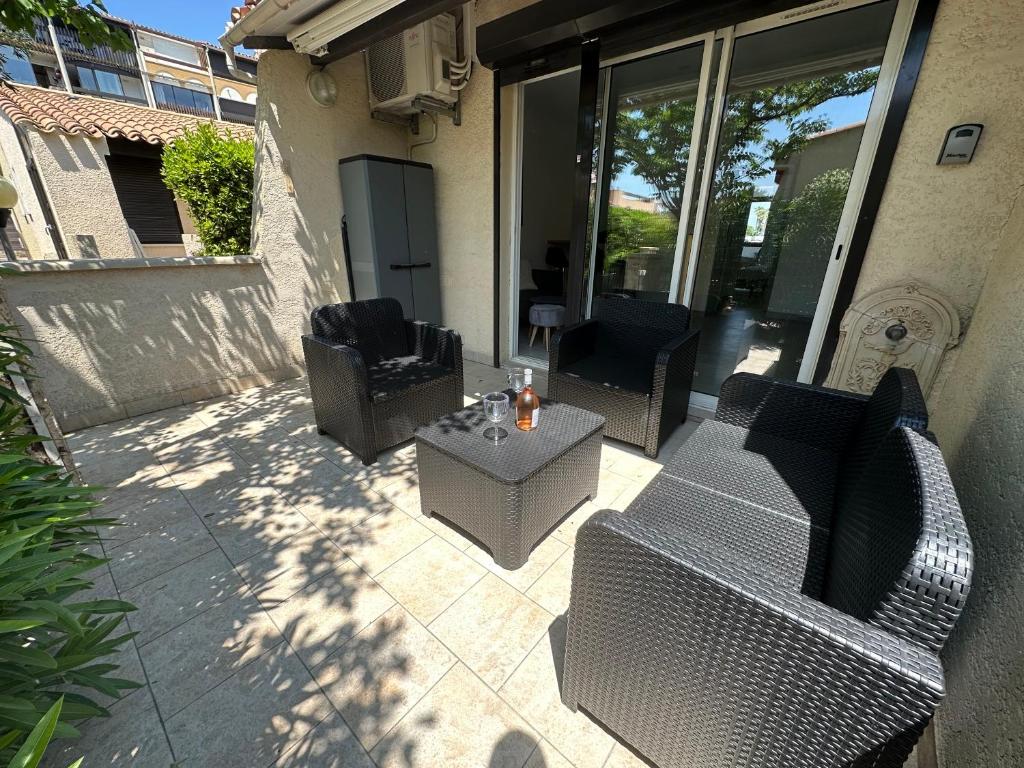 une terrasse avec 2 chaises et une table sur une maison dans l'établissement Village naturiste - Port-Vénus - Villa les pieds dans l'eau, au Cap d'Agde
