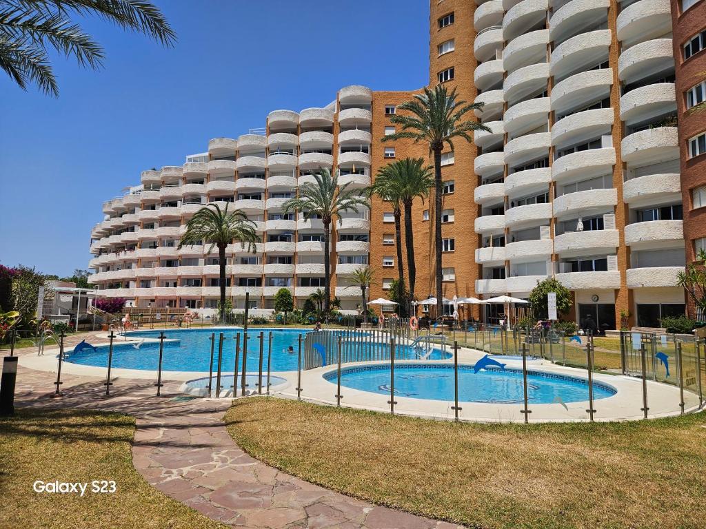 a large apartment building with a swimming pool in front of a building at Julia's apartment in Marbella