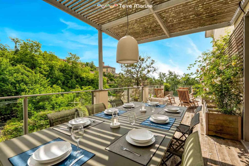 a table with plates and glasses on a patio at Bay View Home, TerreMarine in La Spezia