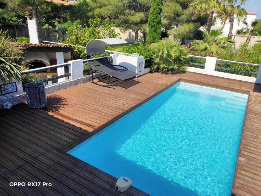 a pool on a deck with a chair next to it at Lavocette maison appartement in Le Grau-dʼAgde