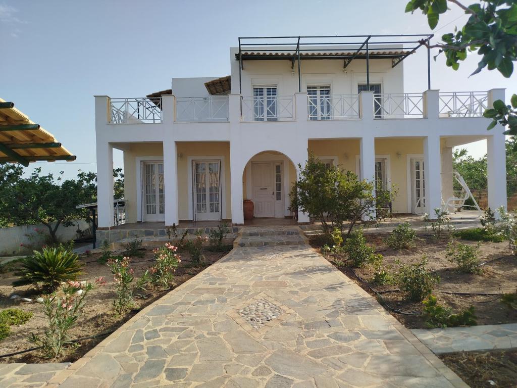 duży biały dom z chodnikiem w obiekcie MOSXONAS House w mieście Áyioi Asómatoi