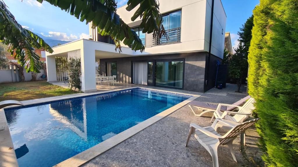 a swimming pool in front of a house at Уютная вилла в Чамьюва in Kemer