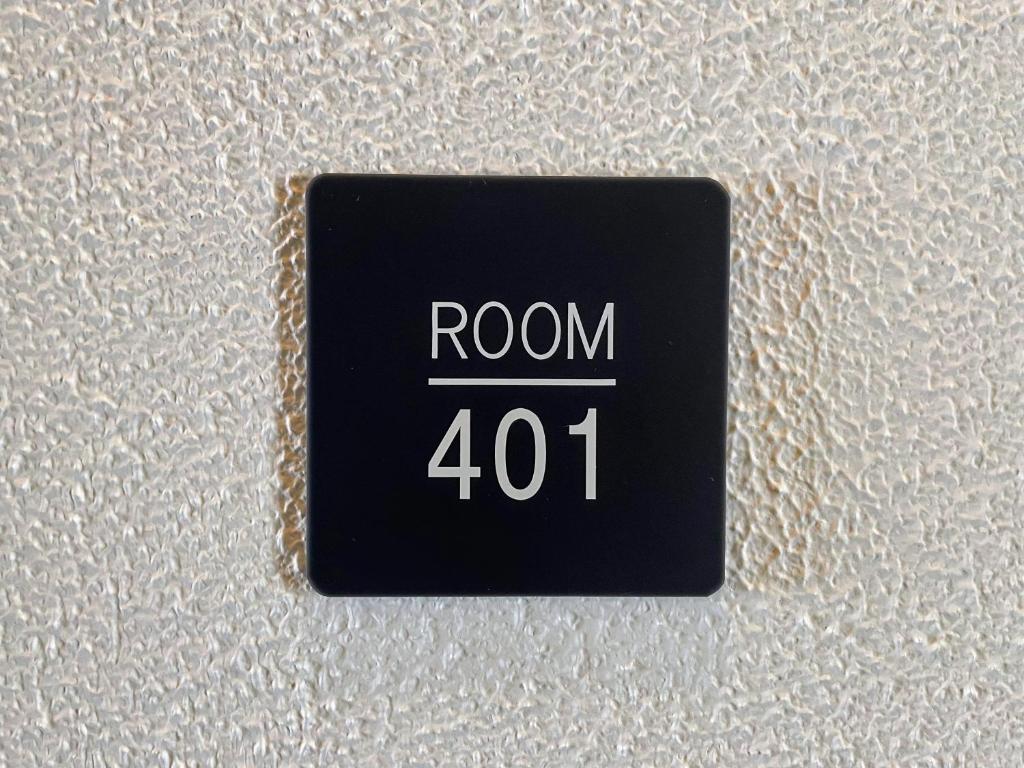 高松市にあるHotel Yuzukiの白い壁に「room」と書かれた黒いボタン
