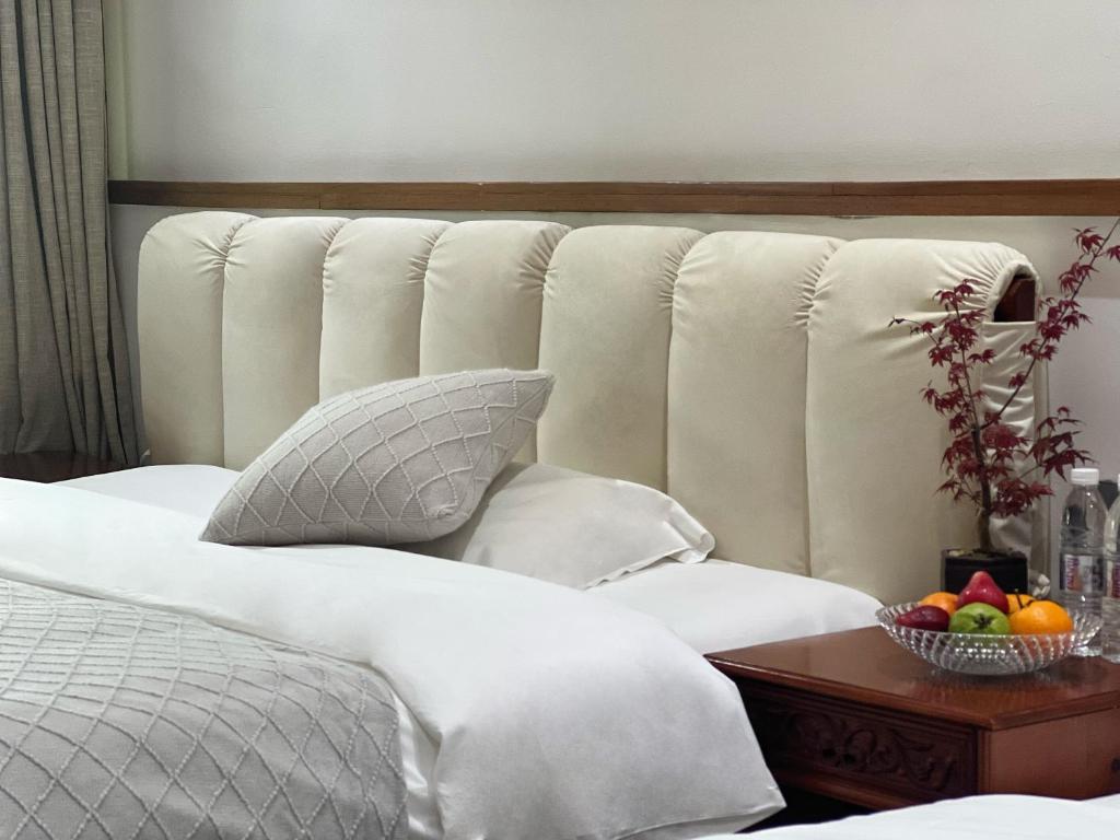 a bedroom with a bed with a bowl of fruit on a table at 原乡文苑客栈 in Lijiang