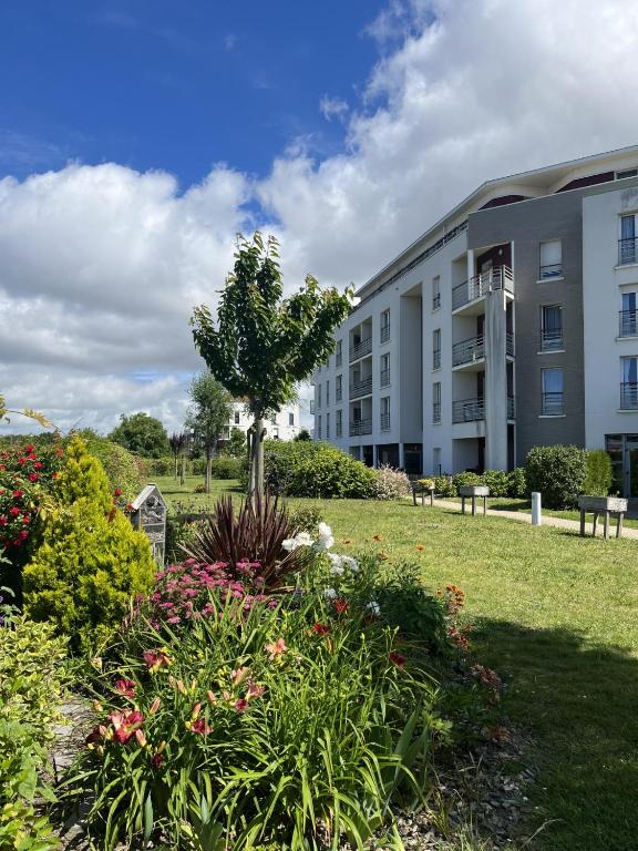 un immeuble d'appartements avec un jardin devant un immeuble dans l'établissement Domitys La Rose des Vents, à Saint-Gilles-Croix-de-Vie
