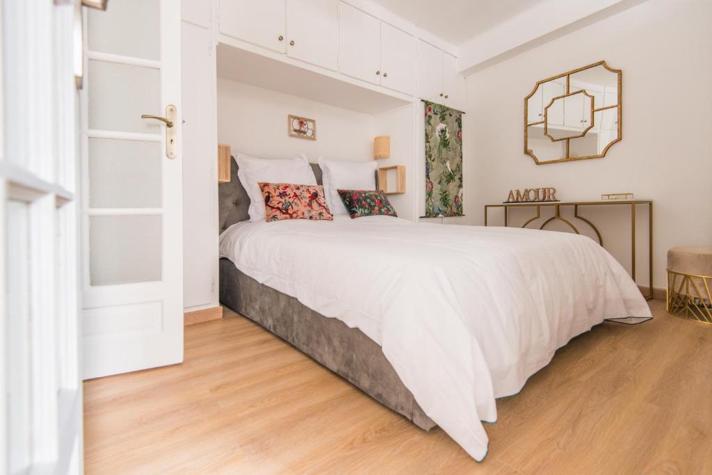 - une chambre blanche avec un grand lit blanc et du parquet dans l'établissement Luxury Art Deco Elegant Escape by Eiffel Tower, à Paris