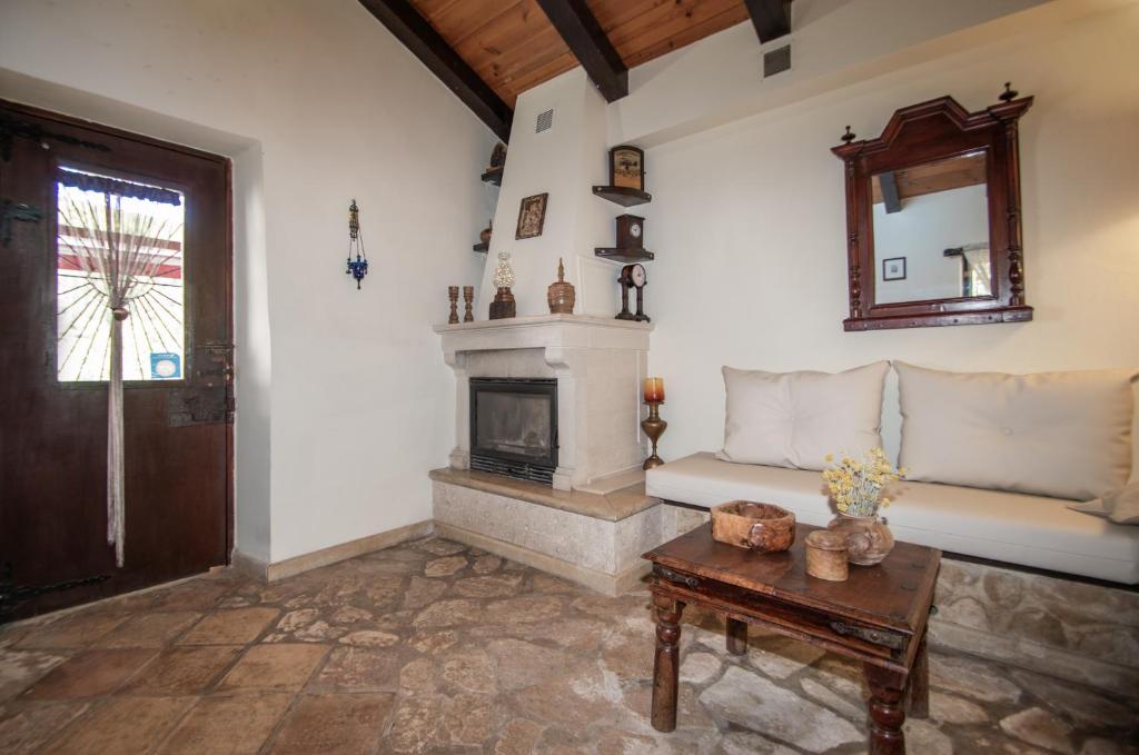 een woonkamer met een bank en een open haard bij Gioia Traditional House in Ágios Nikólaos