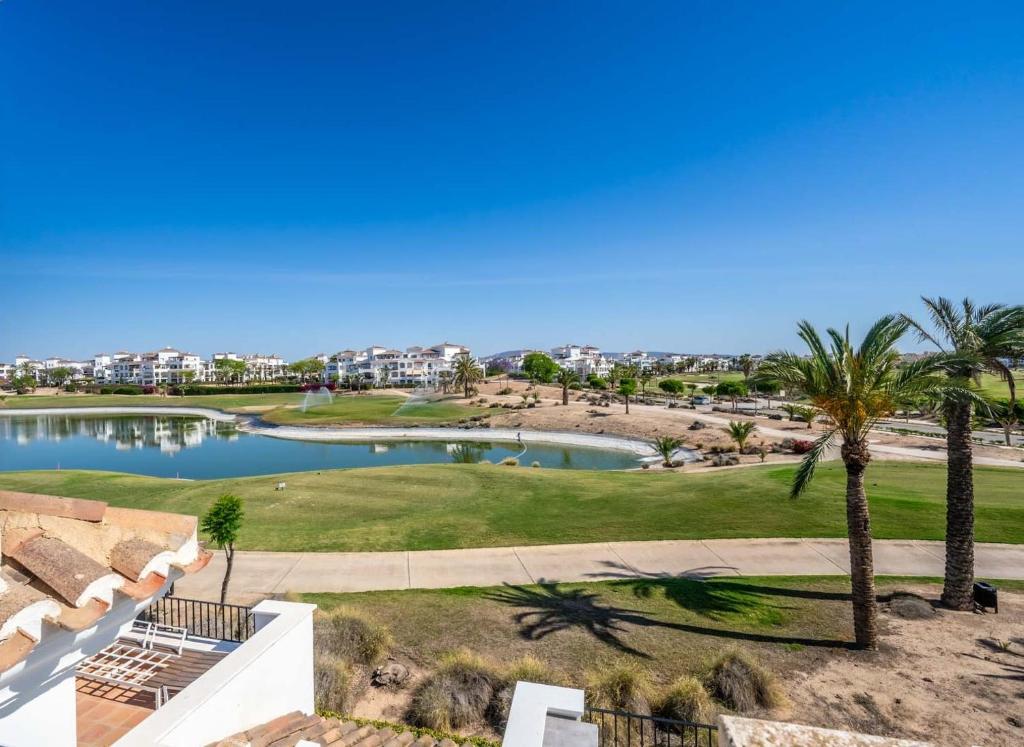 a view from the balcony of a resort with a pond and palm trees at Modern 3 bedroom Town House MA14LT in Torre-Pacheco