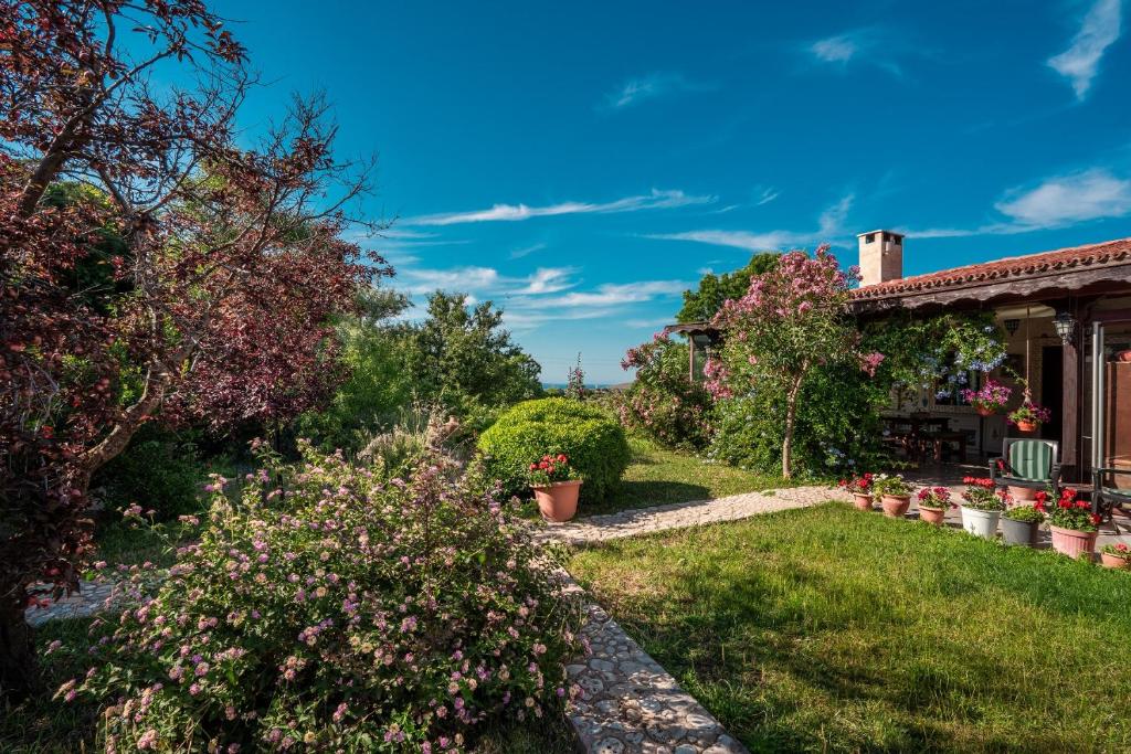 um jardim de uma casa com flores e plantas em Bagbadem Tatil Çiftliği em Bozcaada