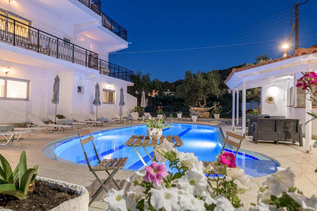 a villa with a swimming pool at night at Denise Studios and Apartments in Argasi