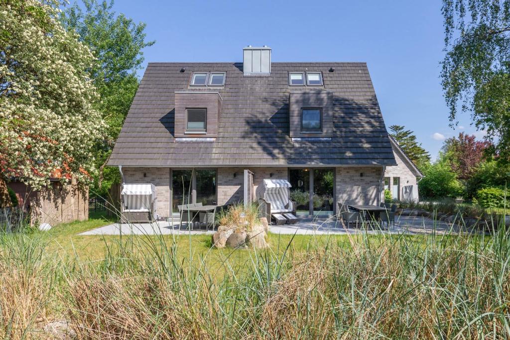a house with two chairs and a table in the yard at Hus Dree in Sankt Peter-Ording
