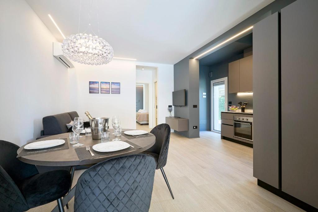 una sala da pranzo e una cucina con tavolo e sedie di The Twins 2 Luxury Home - Lungomare Viale Milano 20 a Riccione