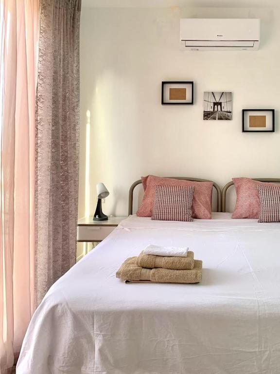 a bedroom with a white bed with a towel on it at Terrace Room on Parish Street in Luqa