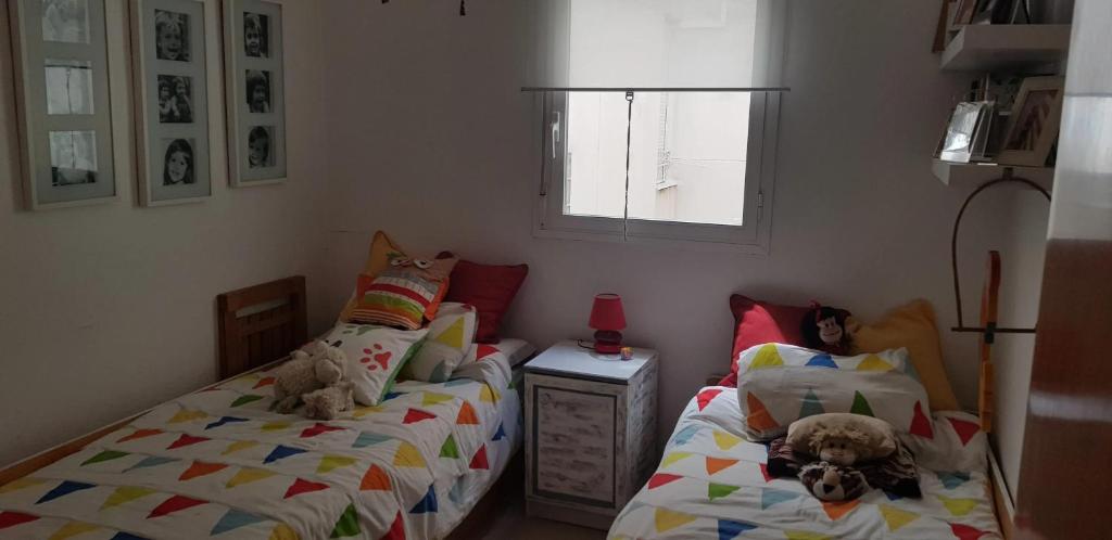 two beds in a bedroom with two dogs laying on them at Modern Apartment in Calafell + Terrace in Calafell