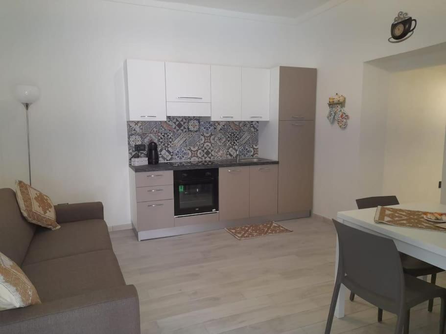 Una cocina y una sala de estar con un sofá y una mesa. en le CASE di BUBU ISOLA DI LA MADDALENA, en La Maddalena