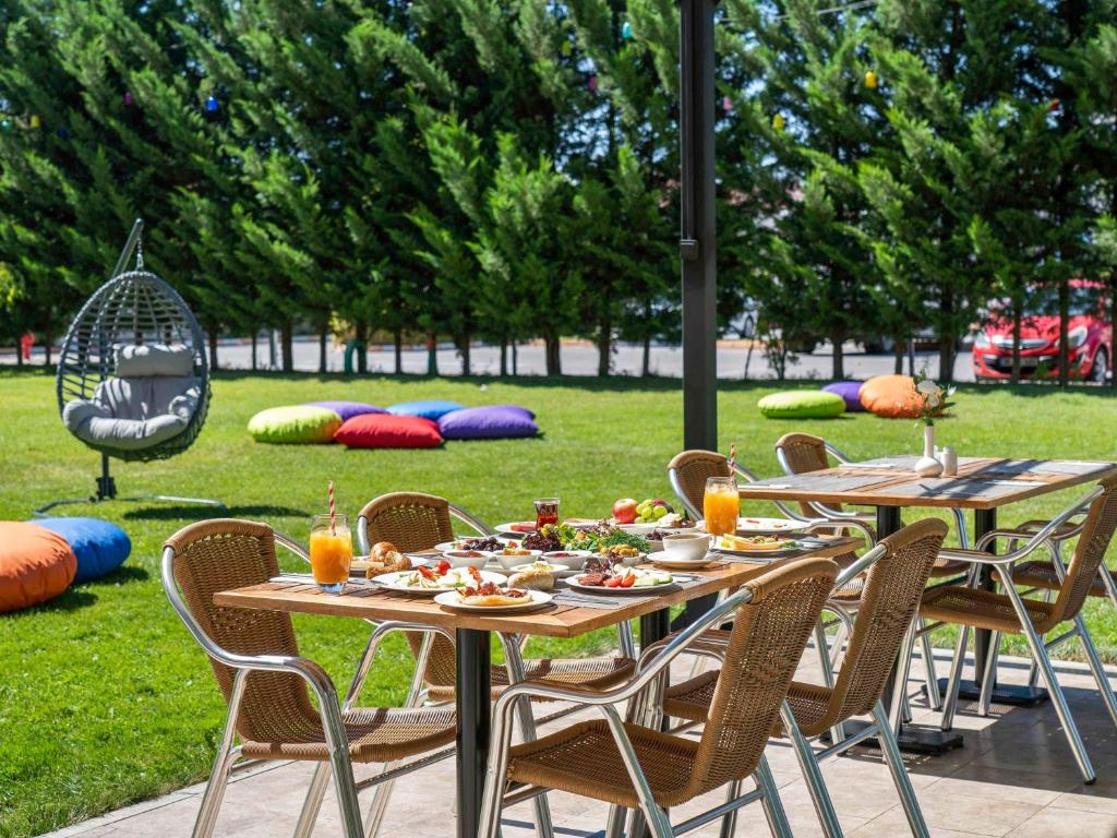 un grupo de mesas y sillas con comida. en Ibis Kayseri en Kayseri