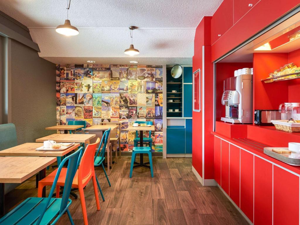 a restaurant with tables and chairs and red walls at hotelF1 Chaumont in Chaumont