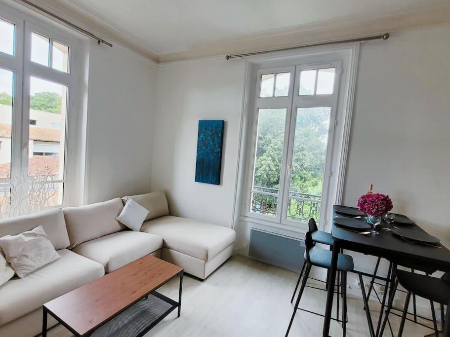 un salon avec un canapé blanc et une table dans l'établissement Appartement lumineux en centre-ville avec parking, à La Rochelle