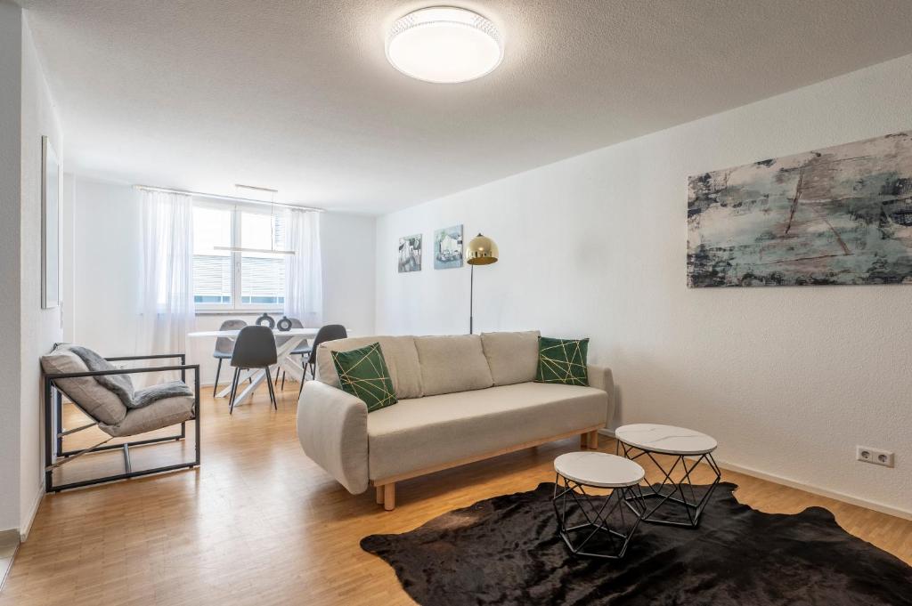 a living room with a couch and a table at EXQUIS 2BR Design Apartment LOUIS I Parking I Balcony I Mercedes-Benz I Family-friendly in Böblingen