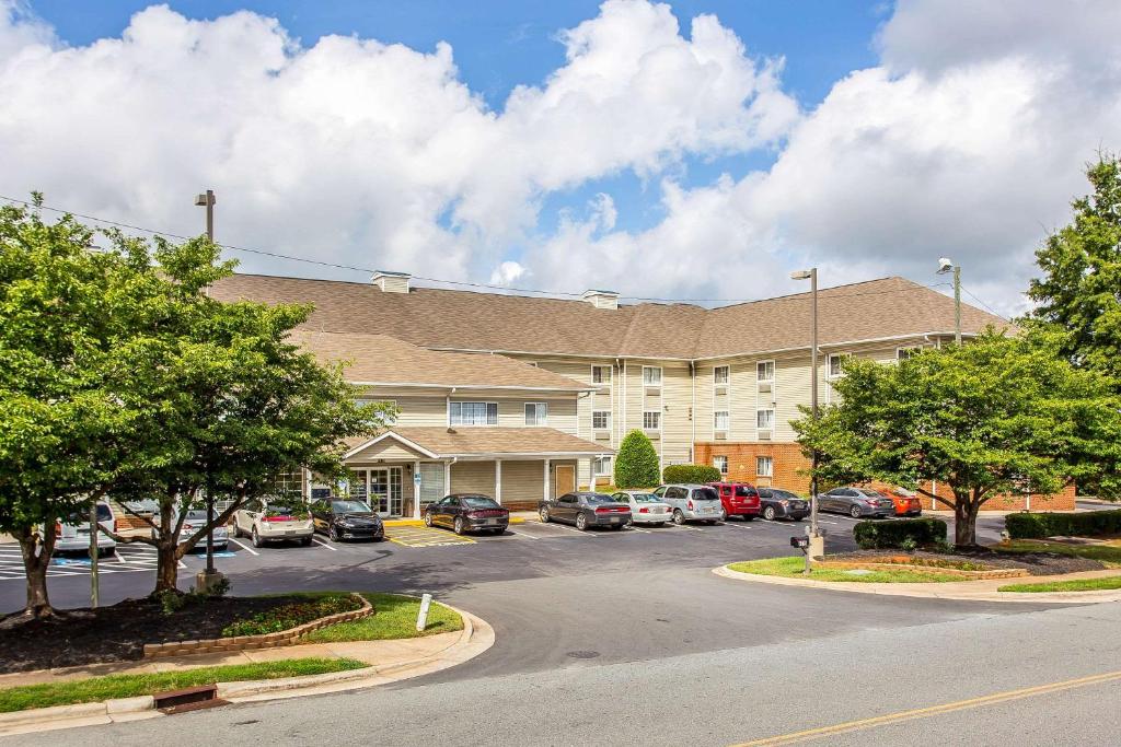 a large building with cars parked in a parking lot at Suburban Studios near University of North Carolina-Charlotte in Charlotte