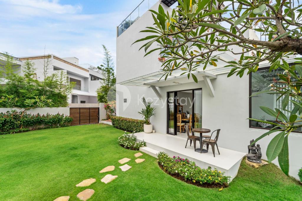 a villa with a lawn in front of it at Jorje Villa by Kozystay - Nusa Dua in Nusa Dua