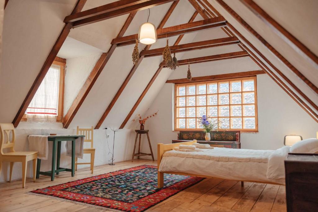 a attic bedroom with a bed and a table at Viscri 9 in Viscri