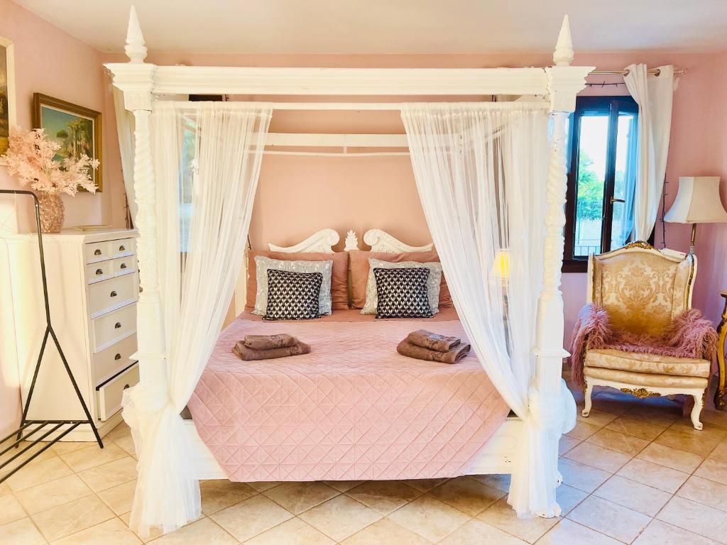 a white canopy bed with curtains in a bedroom at Esmaraldas House of Love in Terrasini