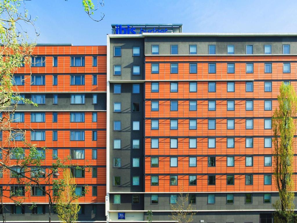 2 immeubles d'appartements avec des panneaux orange dans l'établissement Ibis Budget Paris porte de la Chapelle - Aréna, à Paris