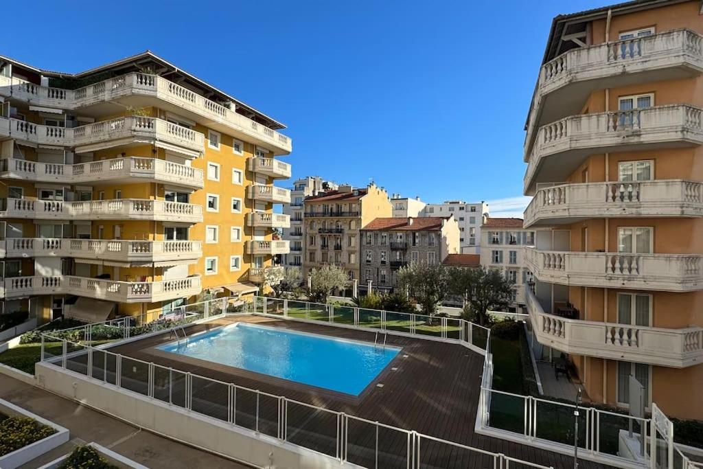 une piscine au milieu de deux bâtiments dans l'établissement Nice Proche Mer, à Nice
