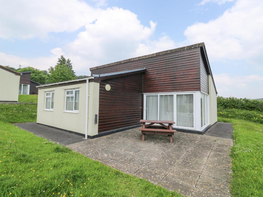 a shed with a bench in front of it at Harcombe House Bungalow 1 in Newton Abbot