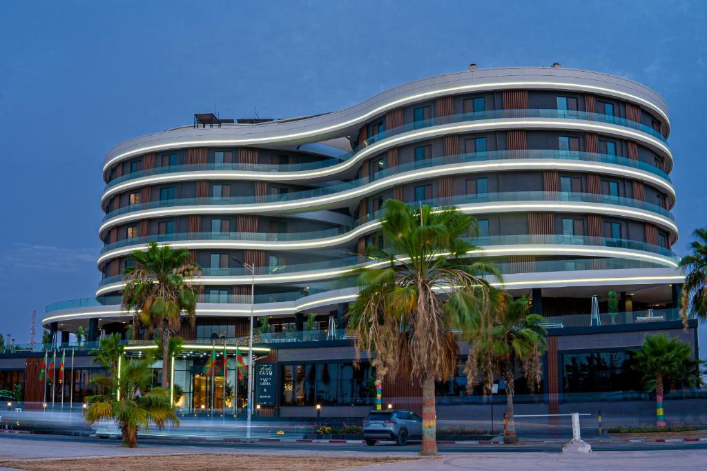 Un gran edificio con palmeras delante. en FASQ Hotel, en Nouakchott