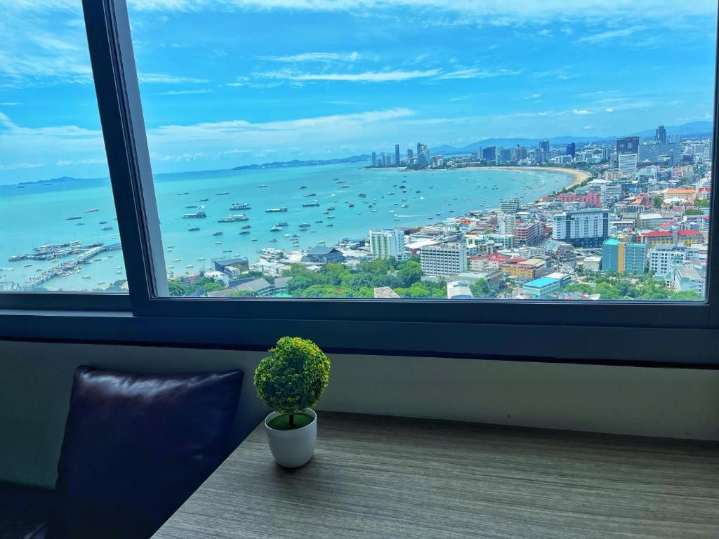 een raam met een potplant en uitzicht op de oceaan bij 2 Bedrooms sea view condo in Pattaya South