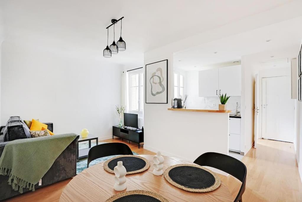 un salon avec une table et une cuisine dans l'établissement Lumineux 2 pièces Batignolles, à Paris