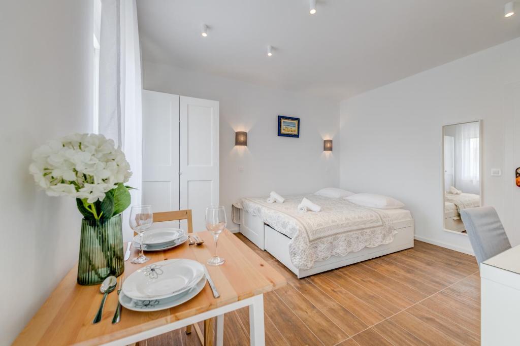a room with a bed and a table with a vase of flowers at Centrally located apartments, free parking in Trogir