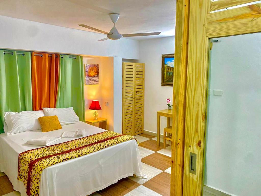 a bedroom with a bed with colorful curtains at Casa Brisa Mar Hotel in Las Terrenas
