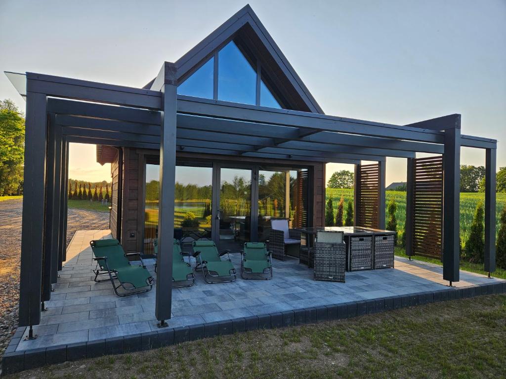 KrasnopolにあるDomek nad jezioremの椅子とグリル付きの焚き火台のあるガゼボ