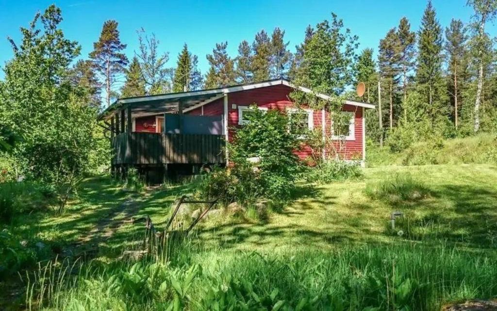 una casa roja en medio de un campo en Gemütliches Ferienhaus in Seenähe, inklusive kostenfreiem Wlan und Ruderboot, en Hallaryd