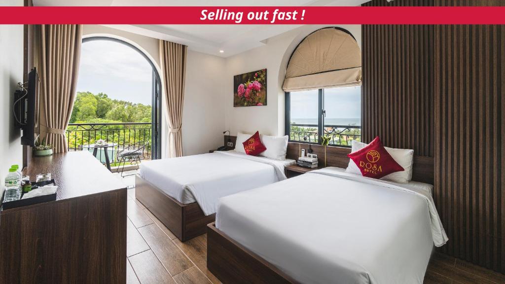 Duas camas num quarto de hotel com varanda em City Center Rosa Hotel em Phu Quoc