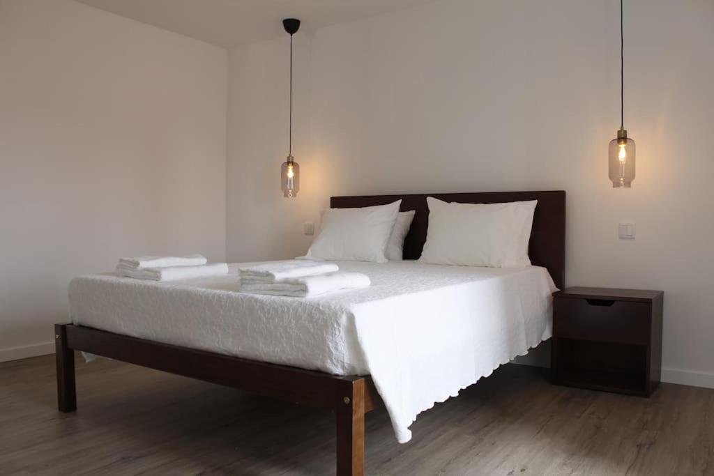 a bedroom with a large bed with white sheets and pillows at Casa na Aldeia in Arcos de Valdevez