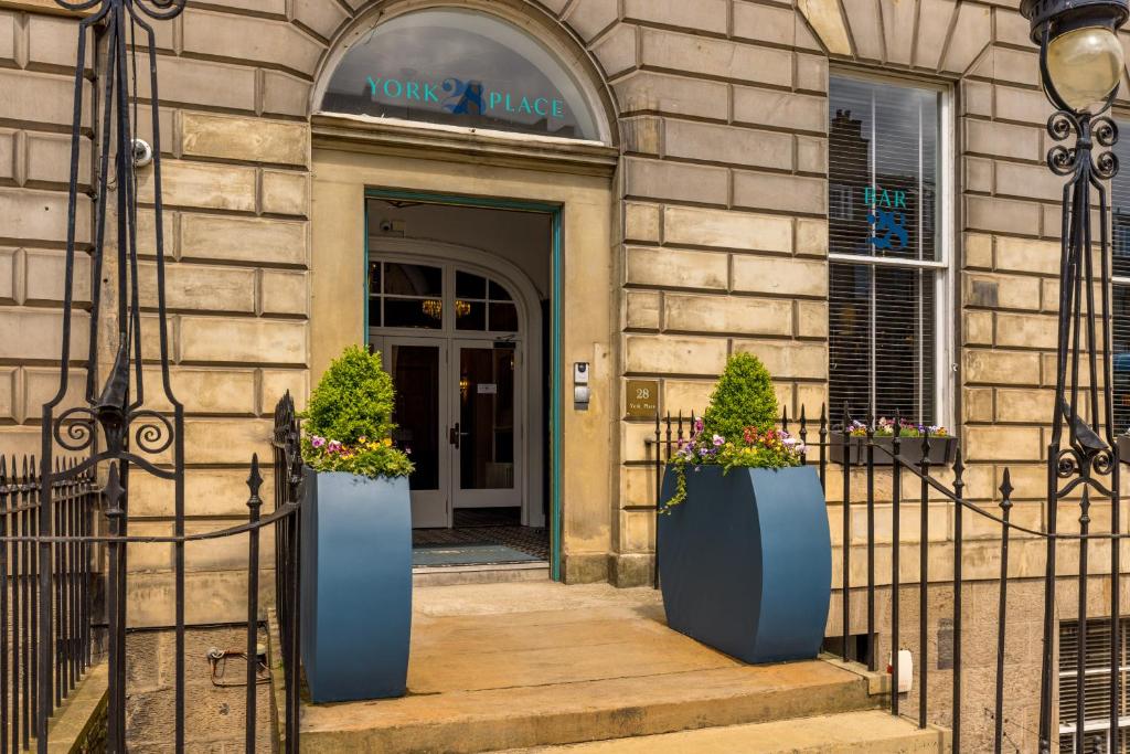 um edifício com dois vasos azuis na frente de uma porta em 28 York Place Hotel em Edinburgo
