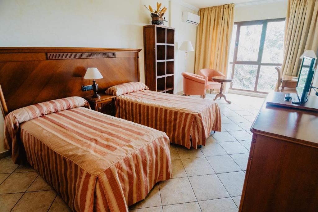 Postel nebo postele na pokoji v ubytování Hotel Hacienda Don Manuel