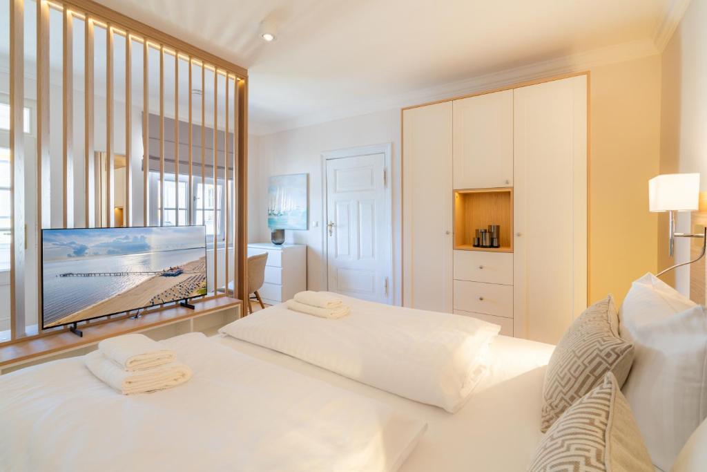 - une chambre blanche avec 2 lits et une grande fenêtre dans l'établissement Villa Albus App 9, à Ahlbeck