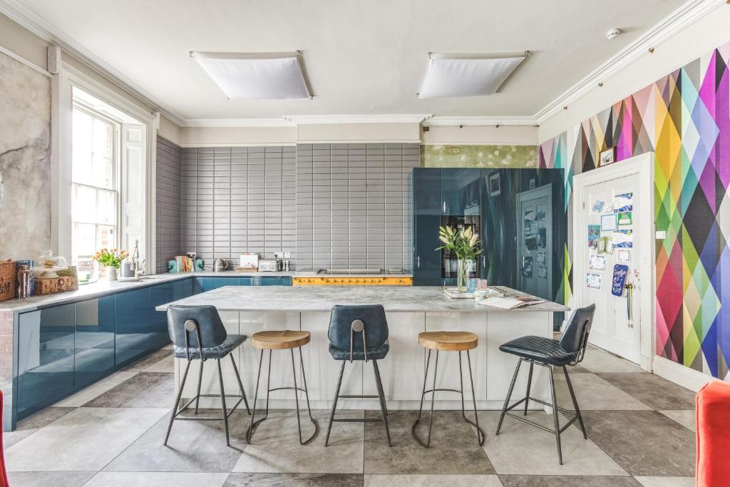 a kitchen with a large island with stools at Friar Gate House - Grand Georgian Townhouse in Derby Centre in Derby