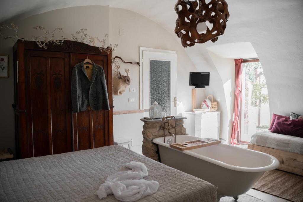 y baño con bañera, cama y bañera. en Baita Naturas con piscina idromassaggio calda, privata e gratuita, en Rossana