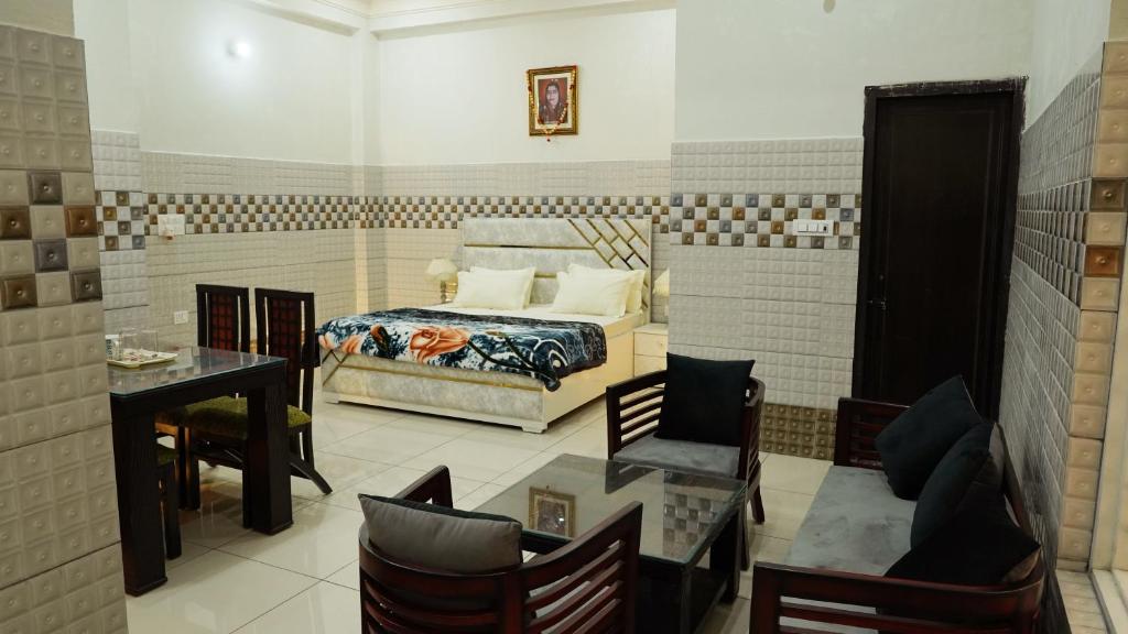 a bedroom with a bed and a table and chairs at Luxury Room with 1 Double Bed in Haridwār