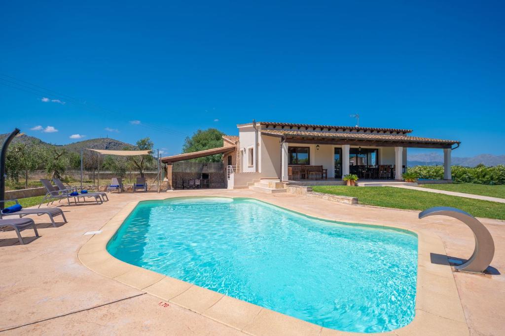 einen Pool in einem Hof mit einem Haus in der Unterkunft Villa Coira in Alcúdia