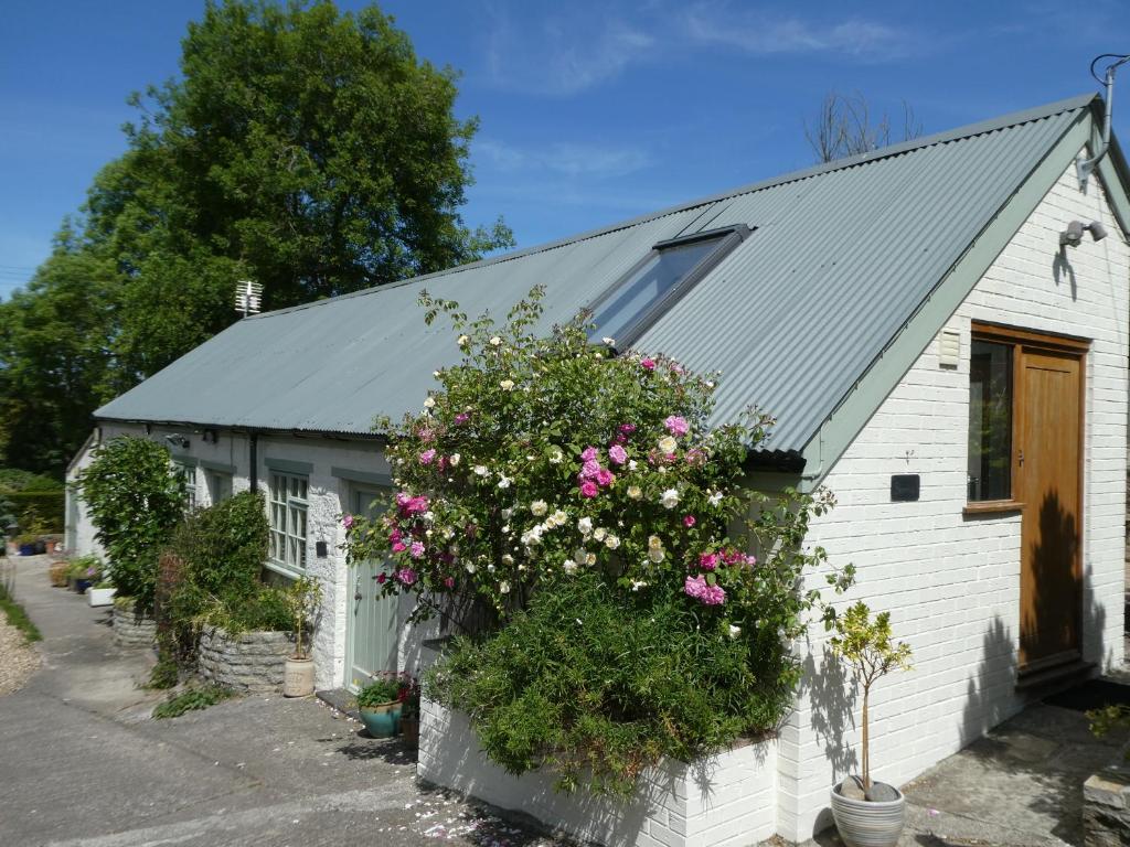 a white building with flowers on the side of it at Bracken in Converted Barn in Dundon