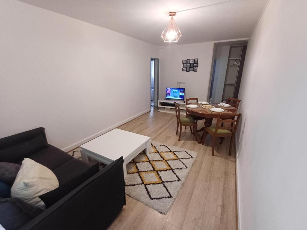 un salon avec un canapé et une table dans l'établissement Appartement cosy à 10 min de Paris, à Aubervilliers