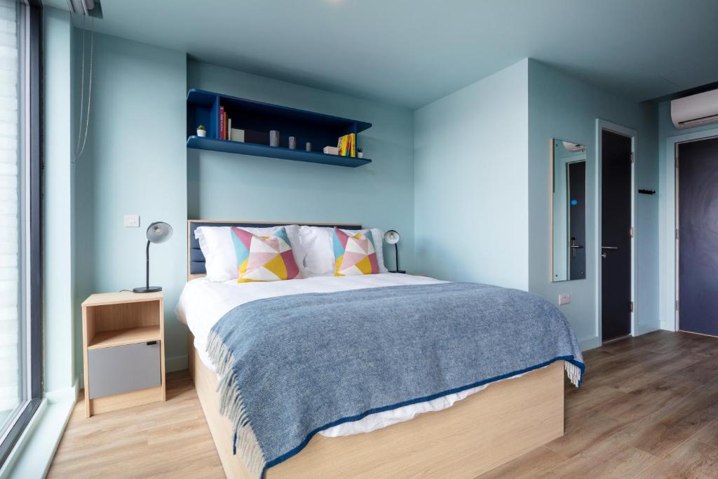 a bedroom with a large bed with a blue wall at Coleman Court Summer Accommodation in Cork